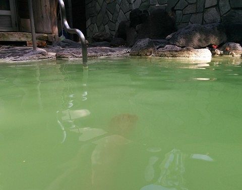緑濁色した露天風呂のお湯